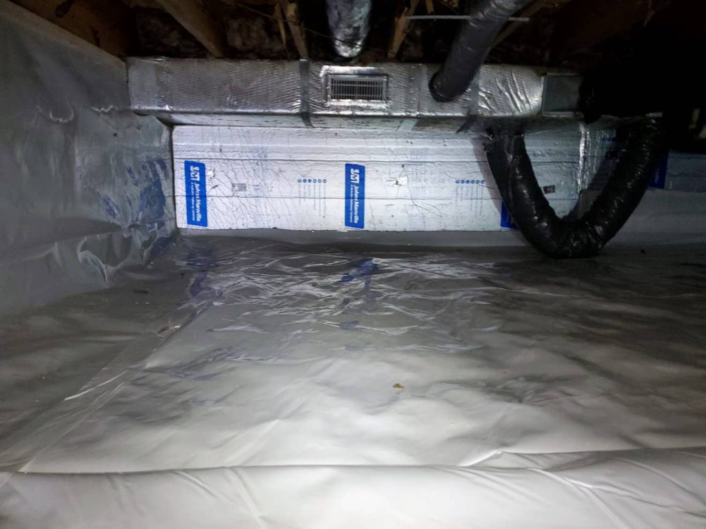Crawl space with encapsulated vapor barrier, visible ductwork, and a wall-mounted HVAC vent register.