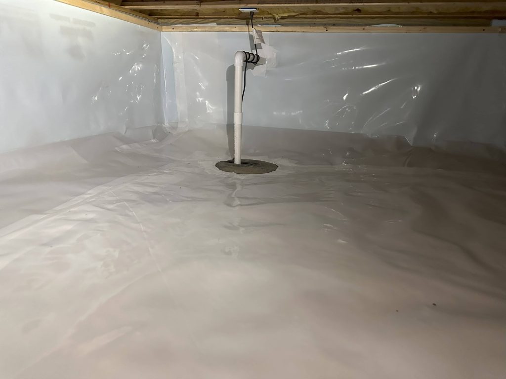 Crawl space with clean white vapor barrier encapsulation and a sump pump system installed for moisture control.