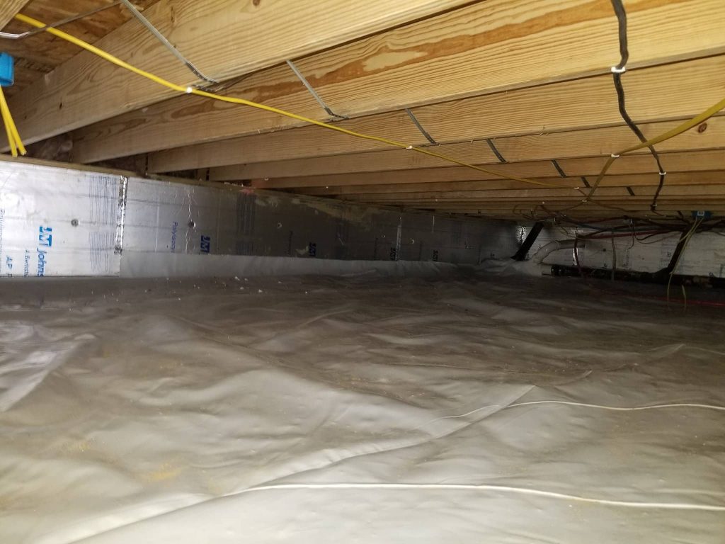 Encapsulated crawl space with plastic vapor barrier on the ground and walls, insulated perimeter walls, and visible electrical wiring along wooden floor joists.