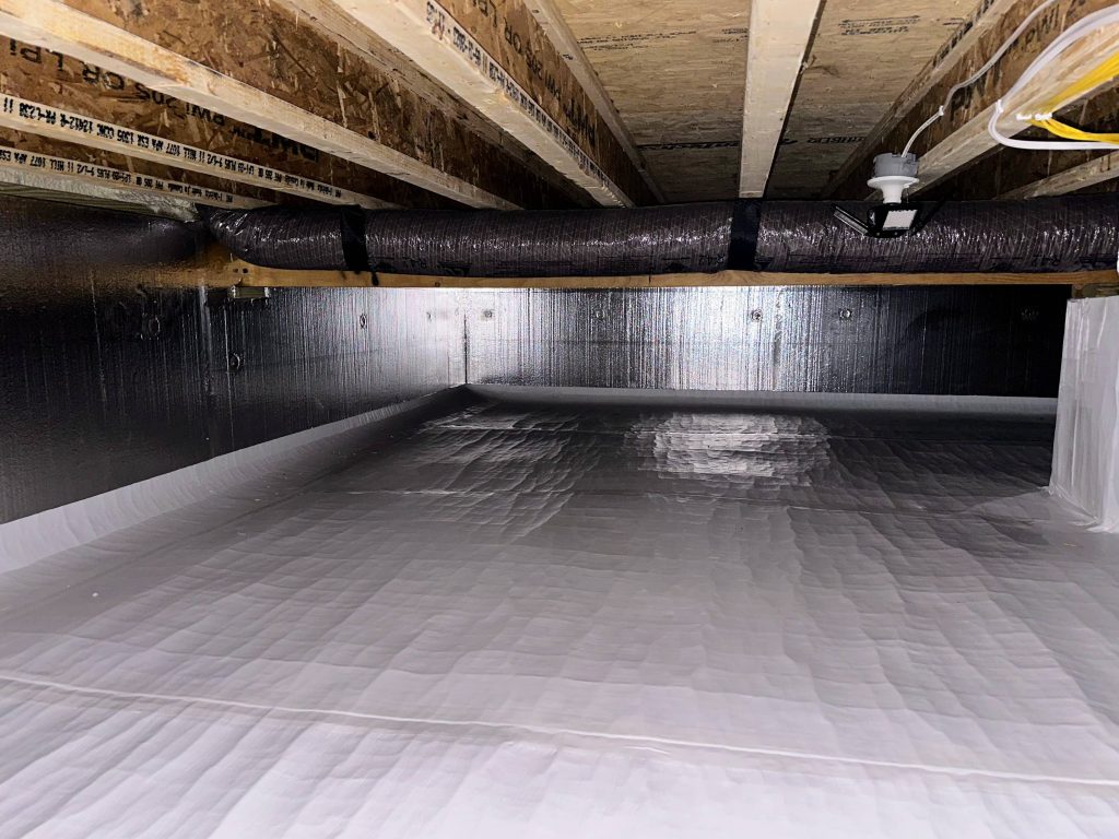 Encapsulated crawl space with white vapor barrier on the floor and insulated walls and ductwork in Bloomington home